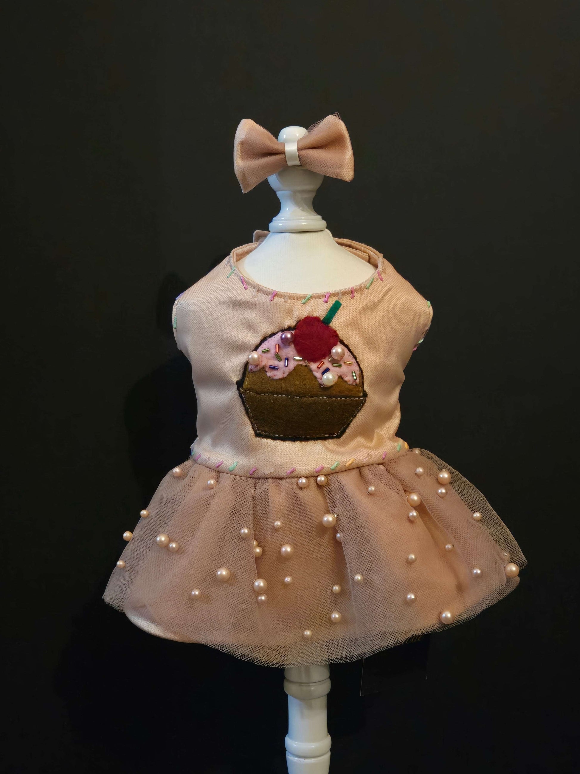 Chocolate Cupcake Fantasy (Chocolat) Dress. All items are Limited Quantity. Custom fabric made from a light brown sateen topped with a darker soft chocolate (chocolat) mesh. Chocolate (chocolat) colored tulle skirt with pearl embellishment. Hand painted sprinkles all over. Multiple layers of paint to give the 3D real sprinkle effect. Hand made felt chocolate cupcake patch with glass pearl and glass bead embellishments topped with a cherry. Matching fabric hair bow with white satin ribbon. 