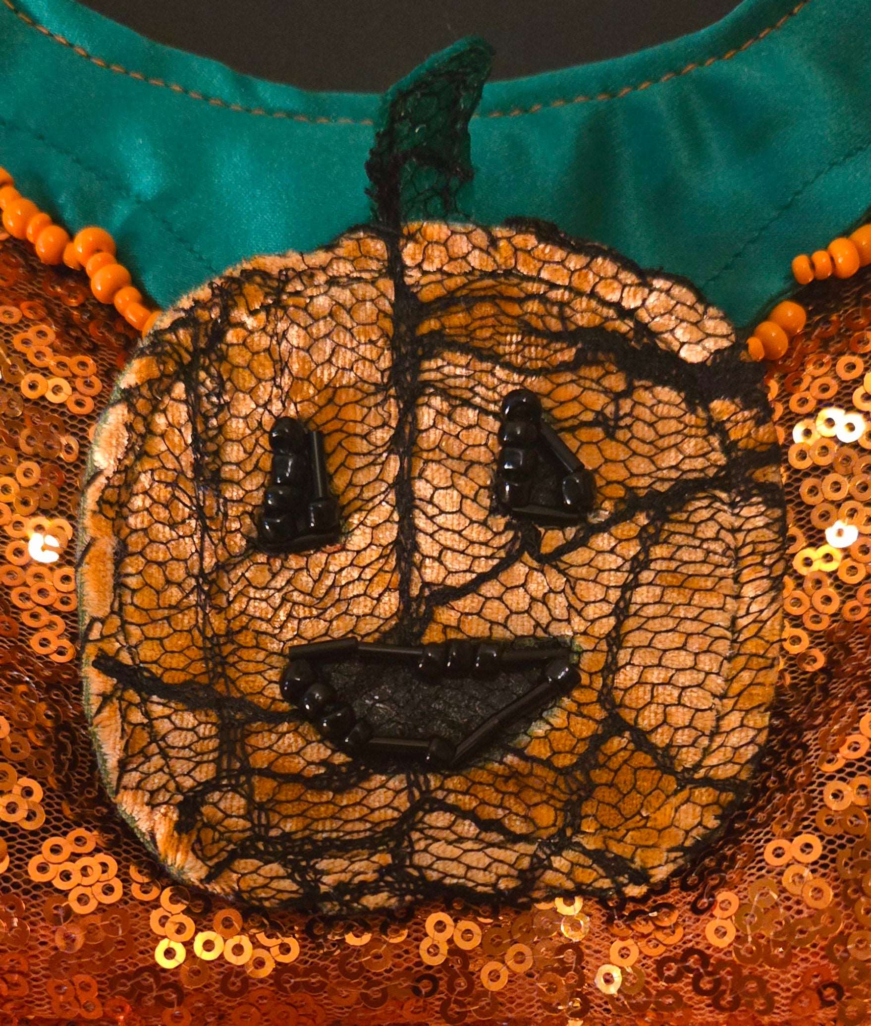 Included is a handmade removable pumpkin embellished patch. Made of matching pumpkin velvet topped with a playful spiderweb lace fabric with black glass bead embellishments at the eyes and mouth.