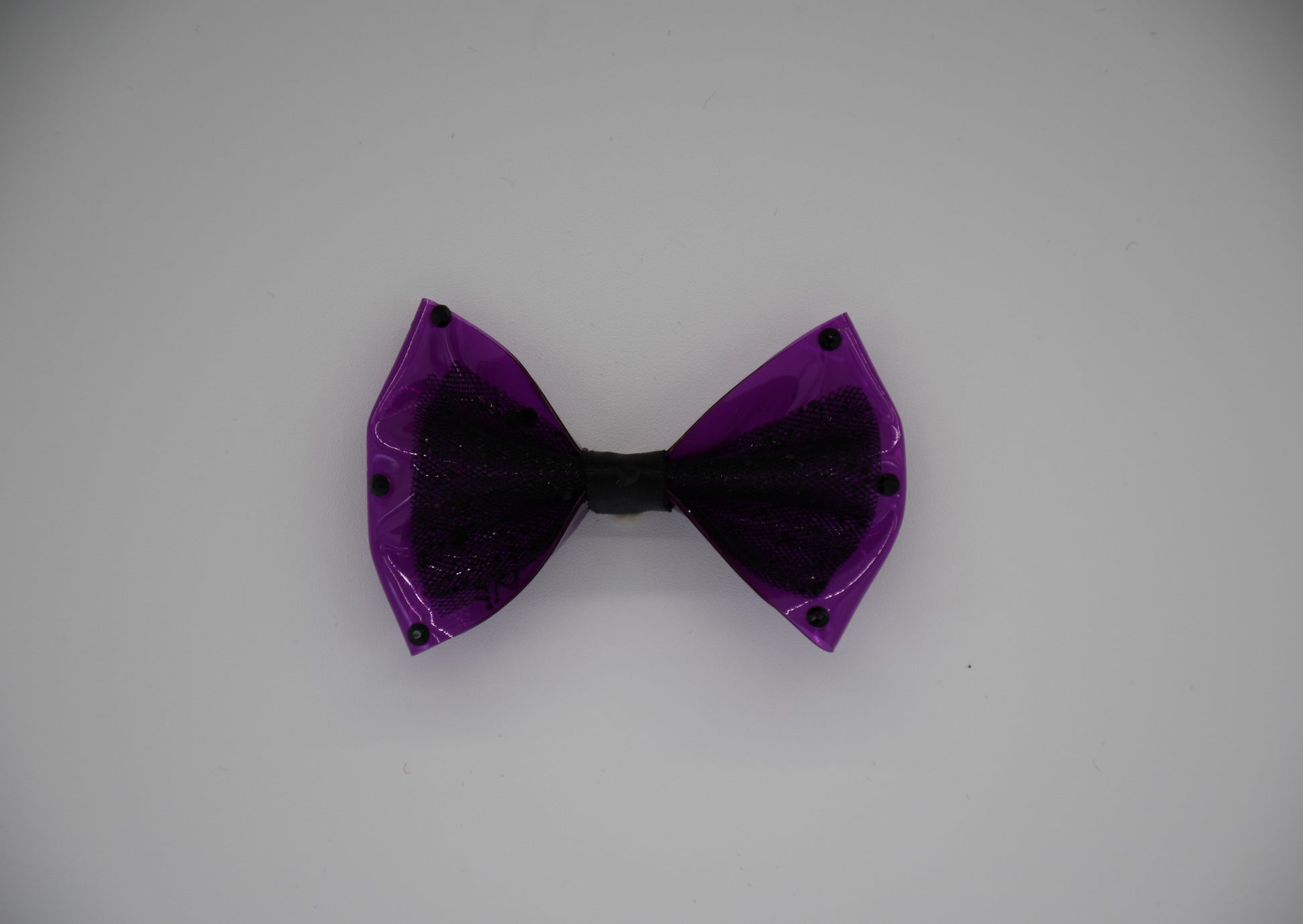 Purple Midnight Orchid Black Crystal Edition. All items are Limited Quantity. Made of Orchid colored clear vinyl fabric. Midnight tulle glitter fabric and hot Pink ribbon.
Carefully hand placed black rhinestone details on edges and center. Hair bow measures 3 inches wide and 2 inches tall.