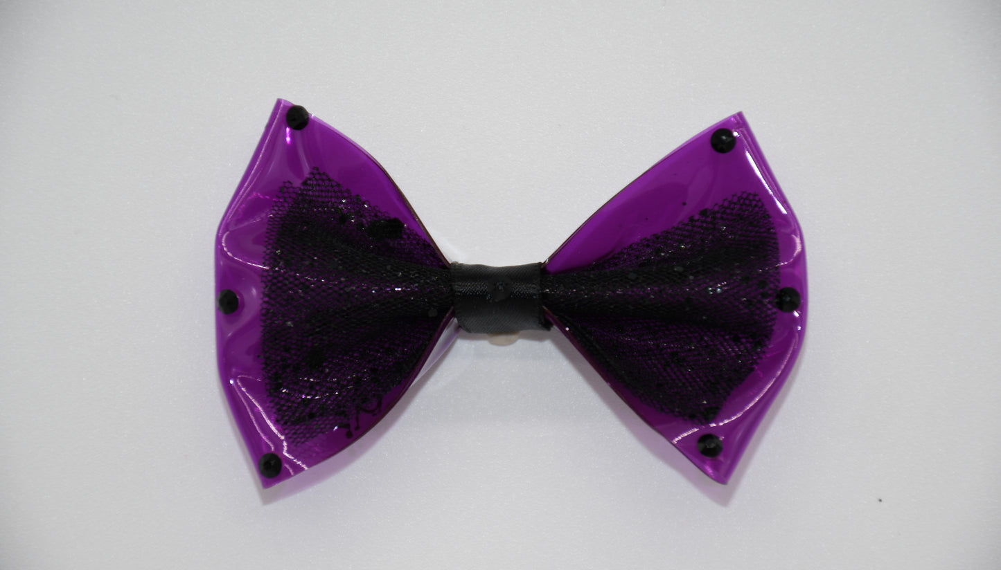 Purple Midnight Orchid Black Crystal Edition. All items are Limited Quantity. Made of Orchid colored clear vinyl fabric. Midnight tulle glitter fabric and hot Pink ribbon.
Carefully hand placed black rhinestone details on edges and center. Hair bow measures 3 inches wide and 2 inches tall.