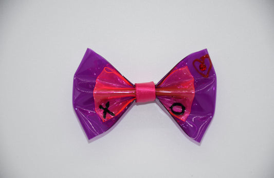 XOXO Mister Fashion Pet Hair Bow. All items are Limited Quantity. Made of a hot pink and orchid clear vinyl fabric. Carefully hand placed red crystal in the center of the heart. Hand Painted heart and XO. Hot pink ribbon. Hair bow measures 3 inches wide and 2 inches tall.