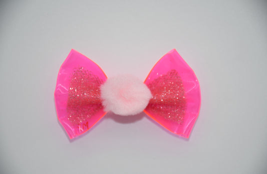 Made of a&nbsp; hot pink clear vinyl fabric.
Glitter tulle fabric
Pink Pom Pom.
Hot pink satin ribbon.&nbsp;
Head Designer Mister Fashion signs or initials all items on backside or somewhere in the lining.
Hair bow measures 3 inches wide and 2 inches tall.