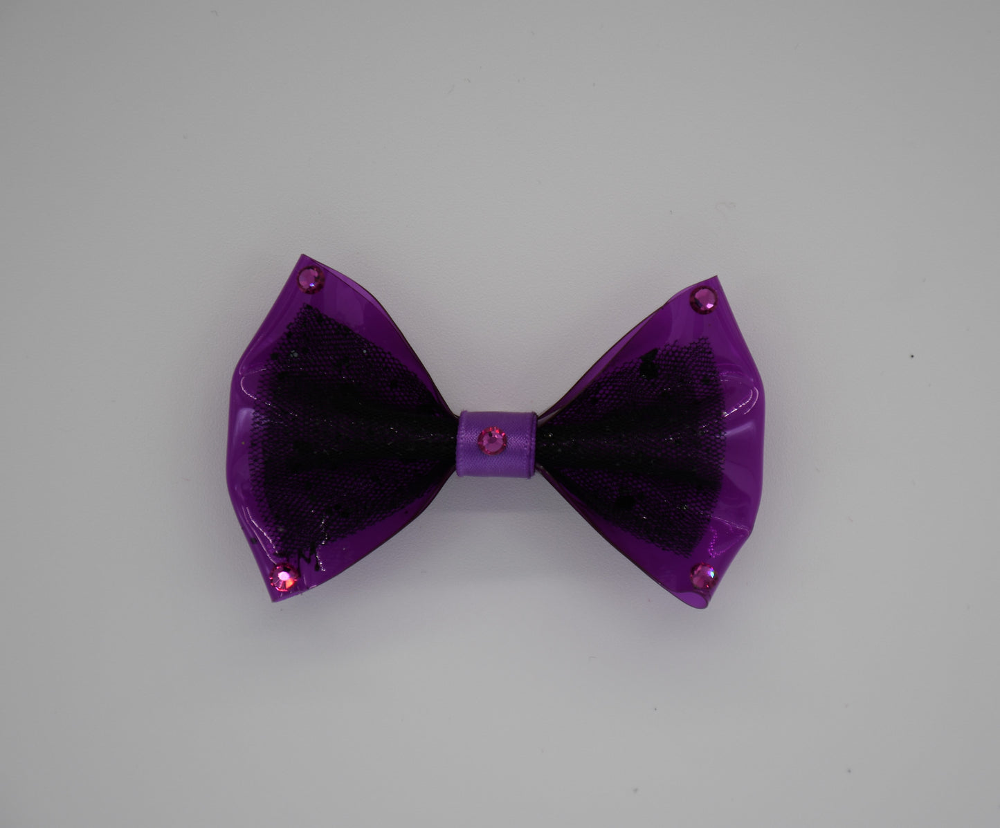 Midnight Orchid. All items are Limited Quantity. Made of Orchid colored clear vinyl fabric.
Midnight tulle glitter fabric and orchid colored satin ribbon.
Carefully hand placed rhinestone details at corners and center.
Hair bow measures 3 inches wide and 2 inches tall.