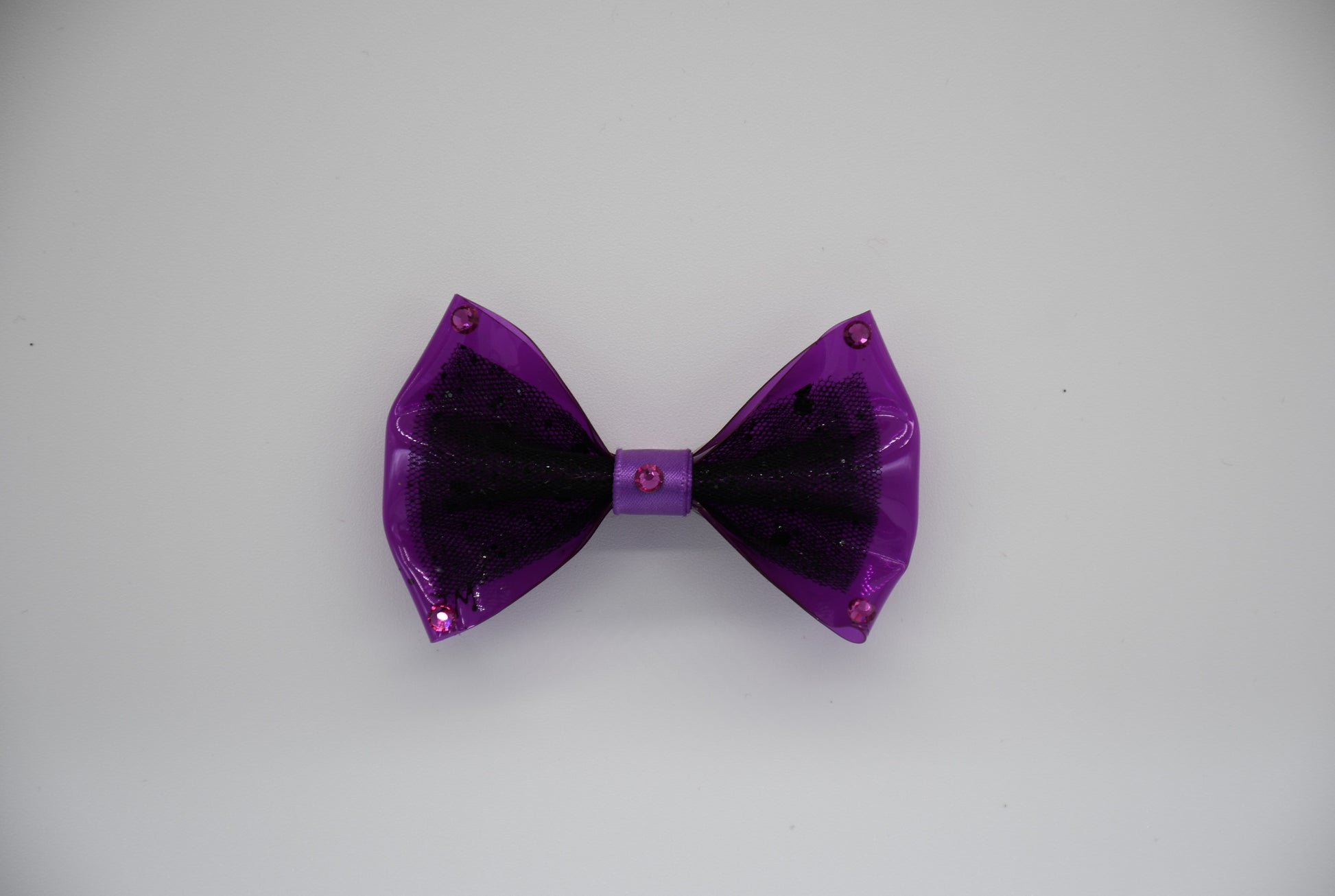 Midnight Orchid. All items are Limited Quantity. Made of Orchid colored clear vinyl fabric.
Midnight tulle glitter fabric and orchid colored satin ribbon.
Carefully hand placed rhinestone details at corners and center.
Hair bow measures 3 inches wide and 2 inches tall.