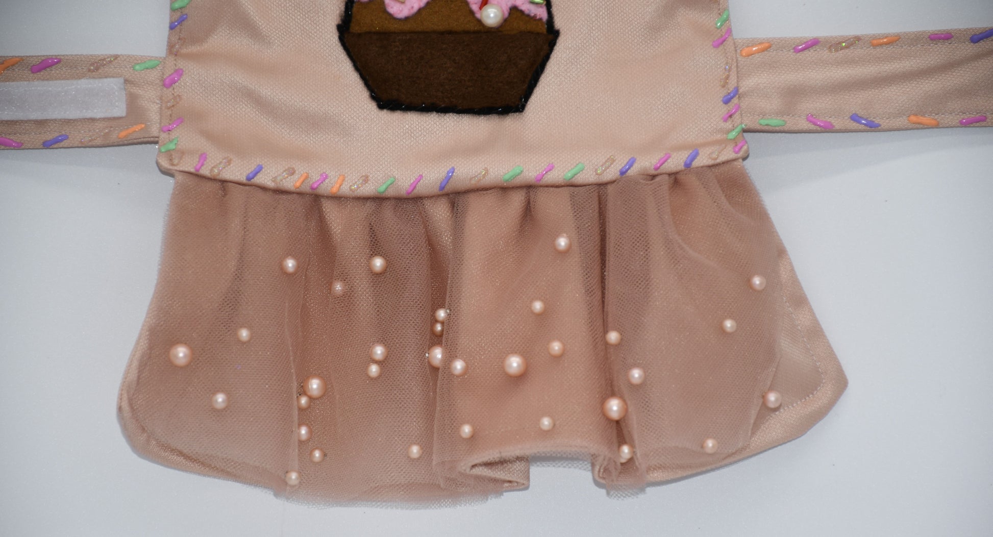 Chocolate Cupcake Fantasy (Chocolat) Dress. All items are Limited Quantity. Custom fabric made from a light brown sateen topped with a darker soft chocolate (chocolat) mesh. Chocolate (chocolat) colored tulle skirt with pearl embellishment. Hand painted sprinkles all over. Multiple layers of paint to give the 3D real sprinkle effect. Hand made felt chocolate cupcake patch with glass pearl and glass bead embellishments topped with a cherry. Matching fabric hair bow with white satin ribbon. 