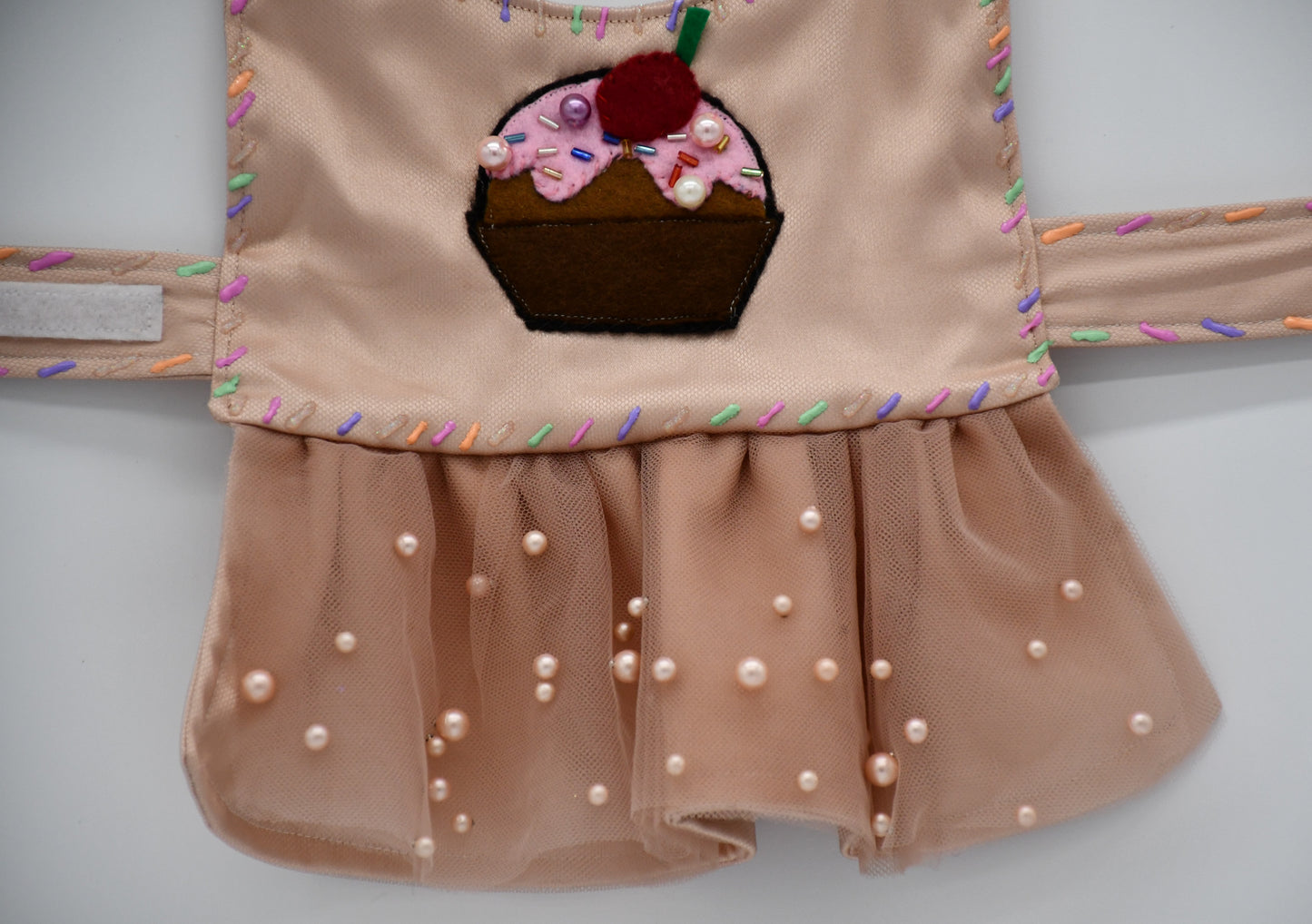 Chocolate Cupcake Fantasy (Chocolat) Dress. All items are Limited Quantity. Custom fabric made from a light brown sateen topped with a darker soft chocolate (chocolat) mesh. Chocolate (chocolat) colored tulle skirt with pearl embellishment. Hand painted sprinkles all over. Multiple layers of paint to give the 3D real sprinkle effect. Hand made felt chocolate cupcake patch with glass pearl and glass bead embellishments topped with a cherry. Matching fabric hair bow with white satin ribbon. 