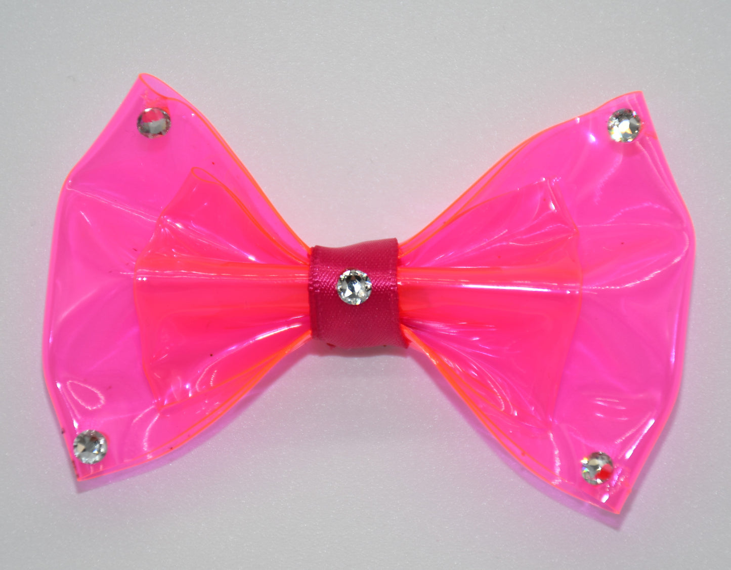 Made of hot pink clear vinyl fabric.
Carefully hand placed white crystals on corners and center.
Hot pink satin ribbon.
Hair bow measures 3 inches wide and 2 inches tall.
Head Designer Mister Fashion signs or initials all items on backside or somewhere in the lining.