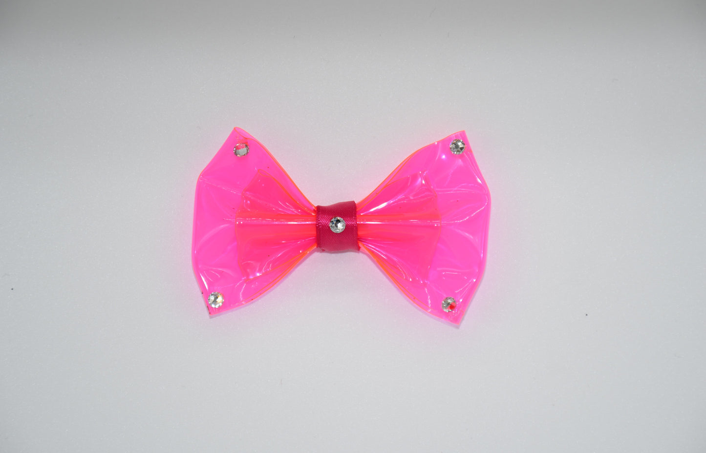 Made of hot pink clear vinyl fabric.
Carefully hand placed white crystals on corners and center.
Hot pink satin ribbon.
Hair bow measures 3 inches wide and 2 inches tall.
Head Designer Mister Fashion signs or initials all items on backside or somewhere in the lining.