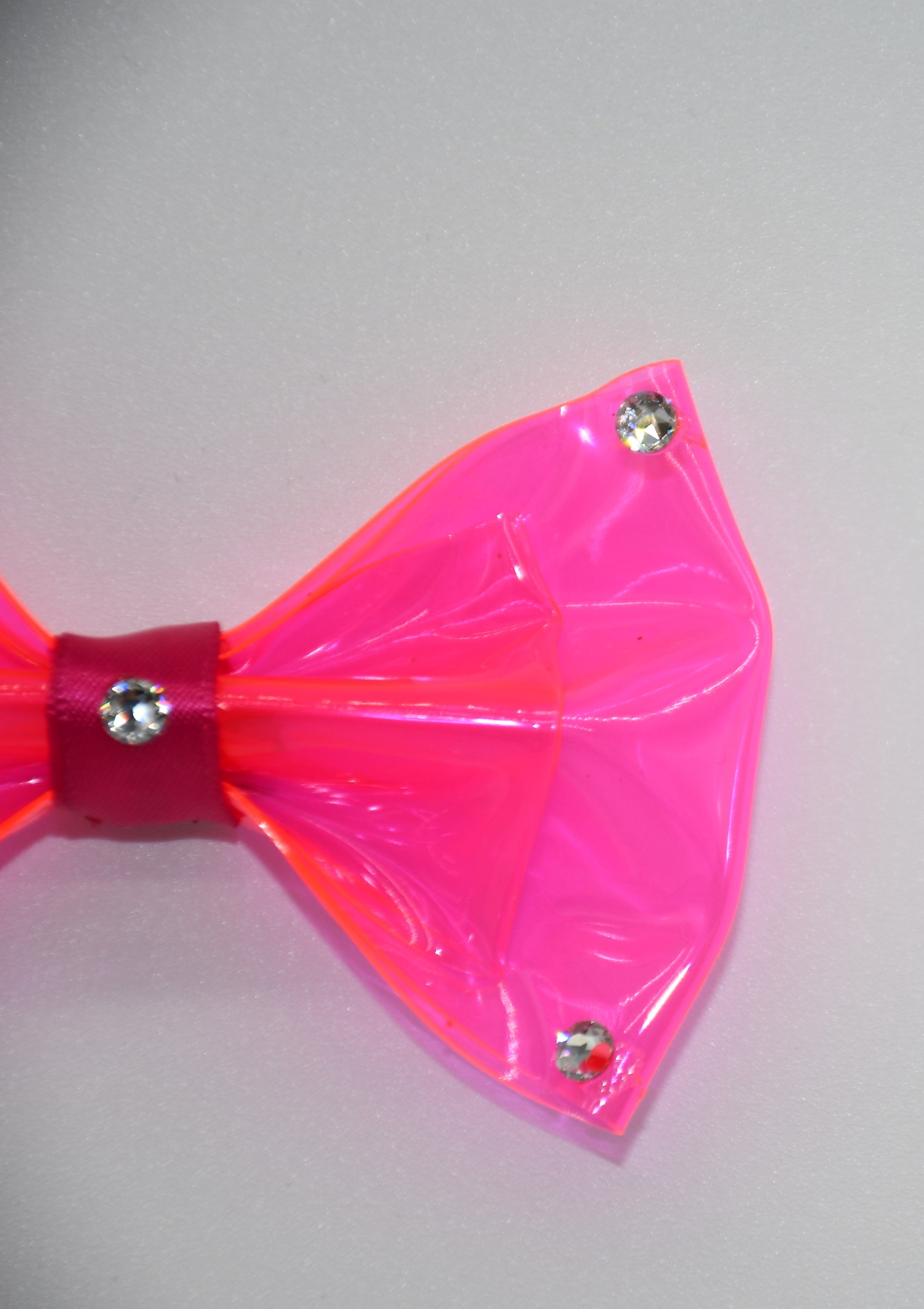 Made of hot pink clear vinyl fabric.
Carefully hand placed white crystals on corners and center.
Hot pink satin ribbon.
Hair bow measures 3 inches wide and 2 inches tall.
Head Designer Mister Fashion signs or initials all items on backside or somewhere in the lining.